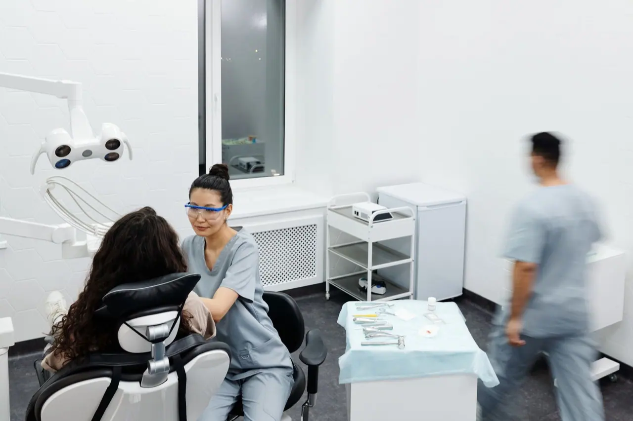 Dentist speaking with a patient in a clinic treatment room