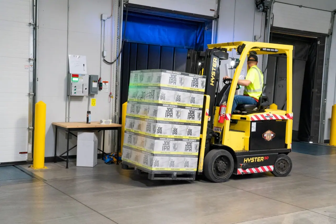 Worker driving a yellow forklift in an industrial building